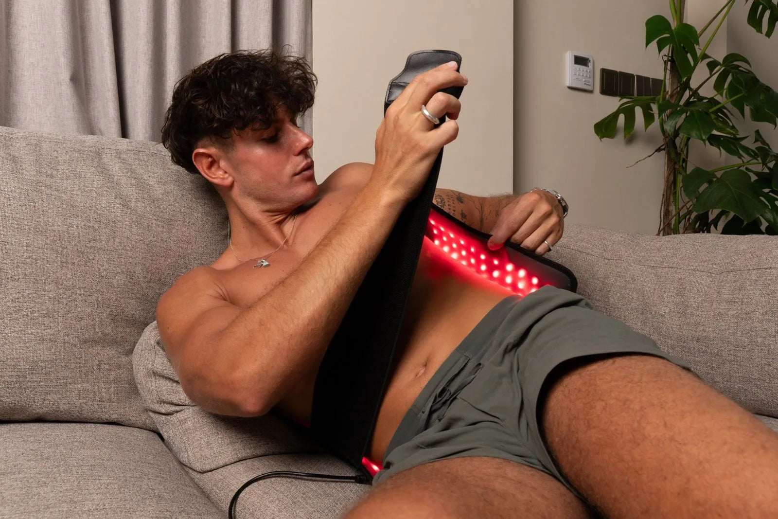 Man fastening the adjustable strap of the ThermoLab Auracell Pro belt around his waist